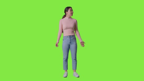 Full-Length-Studio-Shot-Of-Woman-With-Amazed-Expression-Looking-All-Around-In-VR-Environment-Against-Green-Screen